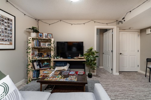 Living area featuring a textured ceiling and light colored carpet - 10906 72 Avenue, Edmonton, AB - Indoor