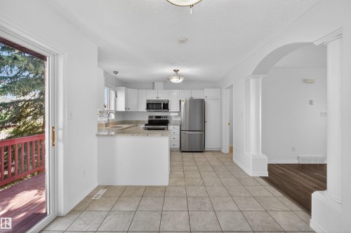 Modern kitchen featuring white cabinetry, stainless steel appliances, and light-toned countertops - 6 1237 Carter Crest Road, Edmonton, AB 