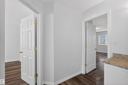 Hallway with light gray walls and wood-finish flooring - 6 1237 Carter Crest Road, Edmonton, AB 