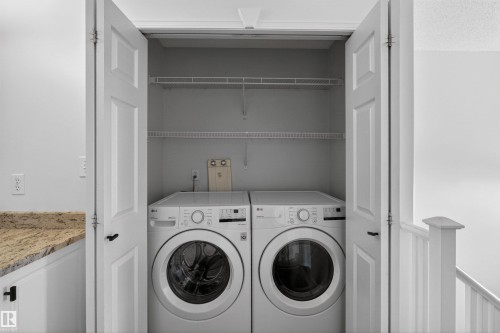 Integrated laundry closet featuring white bi-fold doors and overhead wire shelving - 6 1237 Carter Crest Road, Edmonton, AB 
