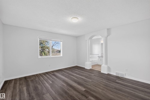 Spacious room featuring wood-finish flooring and a large window - 6 1237 Carter Crest Road, Edmonton, AB 