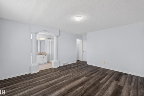 Spacious room featuring wood-finish flooring and light-toned walls - 6 1237 Carter Crest Road, Edmonton, AB 