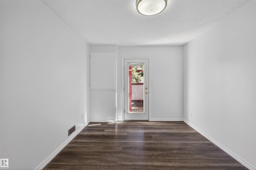 Interior space featuring wood-finish flooring, white baseboards, and a flush-mount ceiling light fixture - 6 1237 Carter Crest Road, Edmonton, AB 