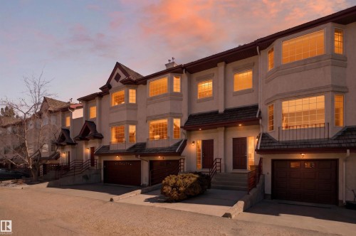 Multi-level townhome featuring a stucco exterior with dark trim and bay windows - 6 1237 Carter Crest Road, Edmonton, AB 