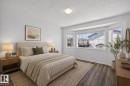 Bright bedroom featuring a bay window, wood-finish flooring, white walls, and a flush-mount ceiling light - 6 1237 Carter Crest Road, Edmonton, AB  - Indoor Photo Showing Bedroom 