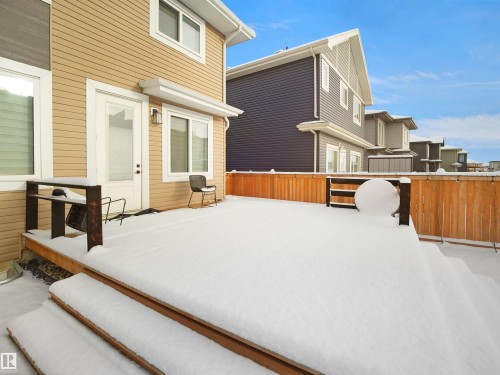 Expansive wooden deck with two steps and a dark metal railing - 20827 130 Avenue Nw, Edmonton, AB - Outdoor With Deck Patio Veranda With Exterior