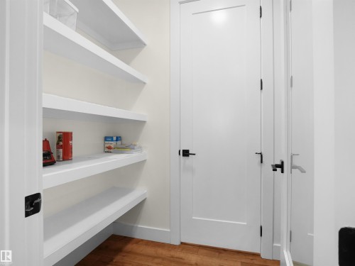 Built-in pantry shelving featuring five levels of storage, white trim, and wood-finish flooring - 20827 130 Avenue Nw, Edmonton, AB - Indoor