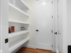Built-in pantry shelving featuring five levels of storage, white trim, and wood-finish flooring - 