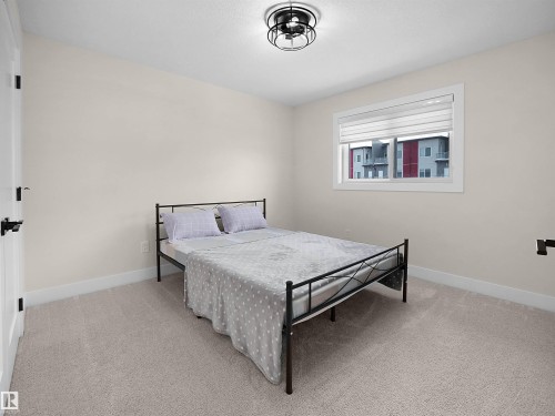 Neutral-toned room featuring a single window with blinds, light-colored walls, and matching carpet flooring - 20827 130 Avenue Nw, Edmonton, AB - Indoor Photo Showing Bedroom