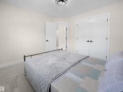 Bedroom featuring light neutral wall paint, white trim, and plush carpeting - 