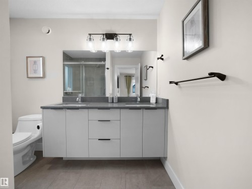 Floating dual vanity with a gray countertop, undermount sinks, and matte black fixtures - 20827 130 Avenue Nw, Edmonton, AB - Indoor Photo Showing Bathroom
