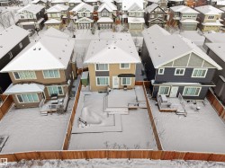Fenced backyard featuring an expansive wood-finish deck and additional ground-level patio space - 
