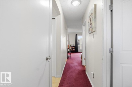 Hallway featuring white paneled doors, light neutral wall paint, and recessed ceiling lighting - 6 3803 76 Street, Edmonton, AB - Indoor Photo Showing Other Room