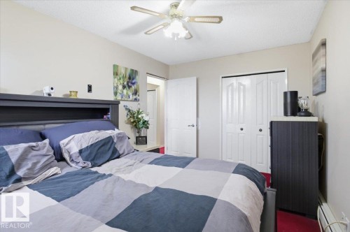 Bedroom featuring a ceiling fan, light-toned walls, white trim, red carpet, and a white interior door - 6 3803 76 Street, Edmonton, AB - Indoor Photo Showing Bedroom