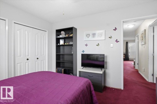 Bedroom featuring white bi-fold closet doors with round black hardware - 6 3803 76 Street, Edmonton, AB - Indoor Photo Showing Bedroom