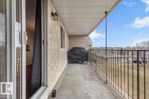Private balcony with concrete flooring, stucco exterior wall, and white vinyl siding - 6 3803 76 Street, Edmonton, AB - Outdoor With Balcony With Exterior