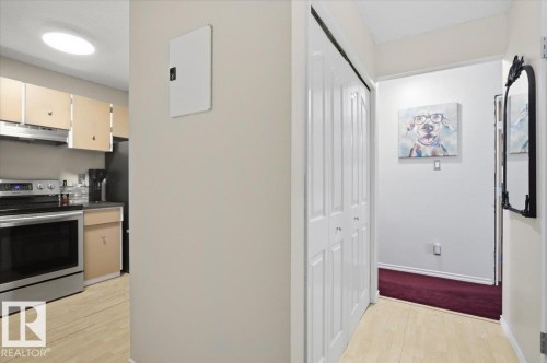 Functional kitchen area featuring stainless steel appliances and wood-finish flooring - 6 3803 76 Street, Edmonton, AB - Indoor Photo Showing Kitchen