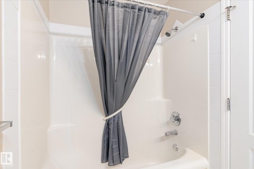 White fiberglass tub and shower combination with chrome fixtures - 203 155 Edwards Drive, Edmonton, AB - Indoor Photo Showing Bathroom