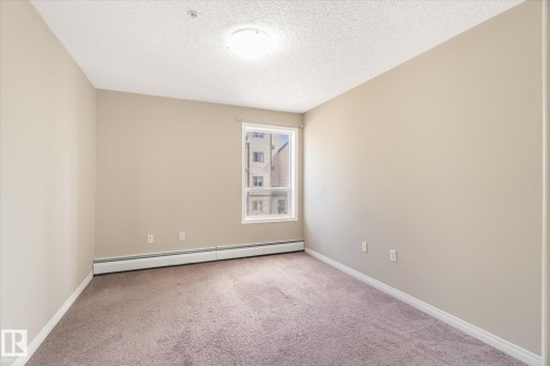 Neutral-toned walls and plush carpeting - 203 155 Edwards Drive, Edmonton, AB - Indoor Photo Showing Other Room