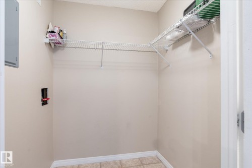 Laundry area with neutral wall paint, wire shelving, and tile flooring - 203 155 Edwards Drive, Edmonton, AB - Indoor With Storage