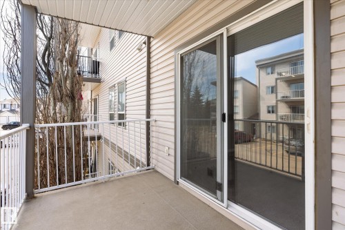 Private balcony with concrete flooring, white metal railing, and vinyl siding - 203 155 Edwards Drive, Edmonton, AB - Outdoor With Balcony With Exterior