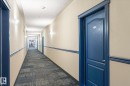 Long hallway with patterned carpet flooring - 203 155 Edwards Drive, Edmonton, AB  - Indoor Photo Showing Other Room 