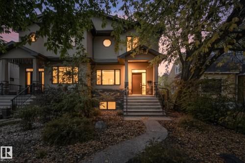 Stucco exterior with stone veneer accents, featuring a prominent front entrance with multiple steps and wrought iron railings - 11106 76 Avenue, Edmonton, AB - Outdoor