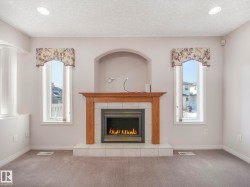 Fireplace featuring a wood-finish mantel and tile surround - 