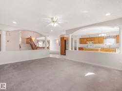 Open-concept living space featuring gray carpet flooring, recessed lighting, and a ceiling fan - 