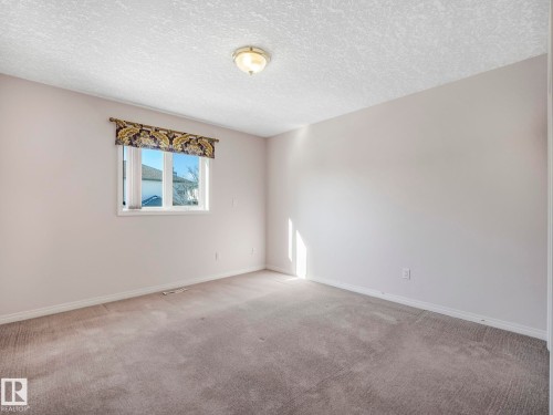 Neutral tone wall paint with window, trim, and baseboards - 1054 Ormsby Crescent, Edmonton, AB - Indoor Photo Showing Other Room