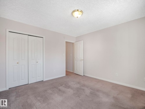 Neutral-toned room with textured carpeting and light-colored walls - 1054 Ormsby Crescent, Edmonton, AB - Indoor