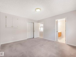 Carpeted interior space featuring light-toned walls and multiple access points - 