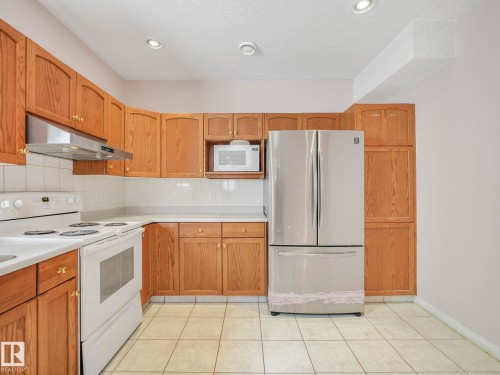 Kitchen featuring oak cabinetry, white tile flooring, white tile backsplash, white countertops, and recessed lighting - 1054 Ormsby Crescent, Edmonton, AB - Indoor Photo Showing Kitchen