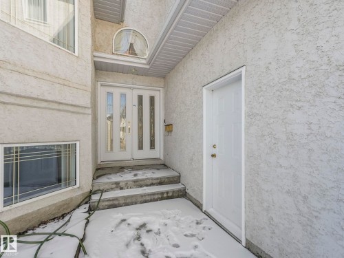 Stucco exterior with a double entry door featuring decorative glass inserts - 1054 Ormsby Crescent, Edmonton, AB - Outdoor With Exterior