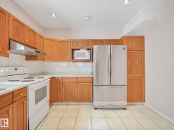 Kitchen featuring oak cabinetry, white tile flooring, white tile backsplash, white countertops, and recessed lighting - 