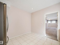 Kitchen area featuring white ceramic tile flooring and a stainless steel refrigerator - 