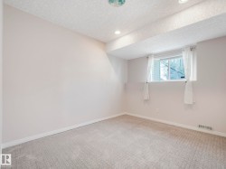 Carpeted room featuring a window with white trim, recessed lighting, and white baseboards - 