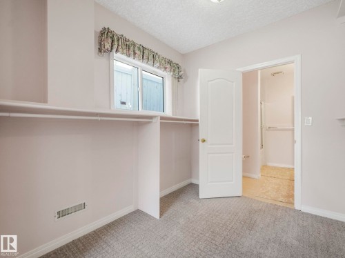 Recessed closet space with built-in shelving and hanging rods - 1054 Ormsby Crescent, Edmonton, AB - Indoor Photo Showing Other Room