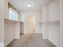 Bedroom closet featuring ample built-in shelving and hanging rods - 
