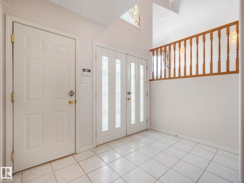 Entryway featuring white tile flooring and a double entry door with decorative glass inserts - 1054 Ormsby Crescent, Edmonton, AB - Indoor Photo Showing Other Room