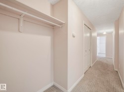 Hallway featuring a built-in closet with shelving and hanging rod - 