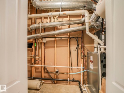 Utility closet with exposed ductwork, piping, and a visible furnace unit - 1054 Ormsby Crescent, Edmonton, AB - Indoor