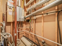 Tankless water heater installation, visible plumbing, and electrical components - 