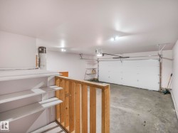 Spacious garage with a single overhead door, concrete flooring, and bright overhead lighting - 