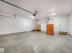 Spacious garage featuring a concrete floor, multiple entry points, and an overhead garage door opener - 