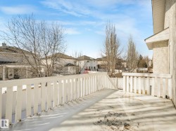 Exterior deck with white painted railings and a stucco-clad wall - 