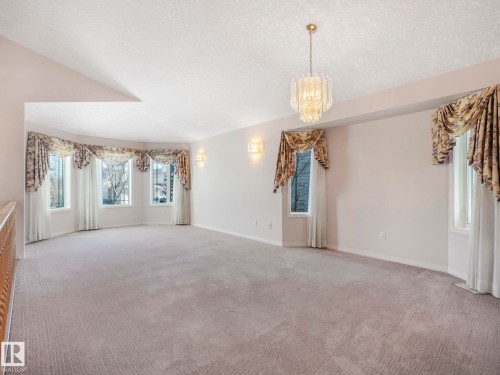 Spacious room featuring light-toned carpet flooring and a multi-pane bay window with decorative valances - 1054 Ormsby Crescent, Edmonton, AB - Indoor Photo Showing Other Room