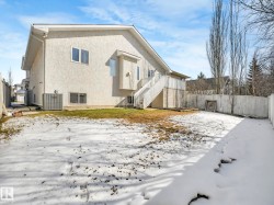 Spacious rear yard with a white wooden privacy fence - 