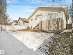 Expansive backyard featuring a white picket fence and a multi-level deck with white railings - 