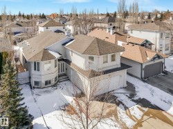 Two-story stucco residence featuring a multi-faceted roofline, front-facing attached garage, and a bay window elevation - 